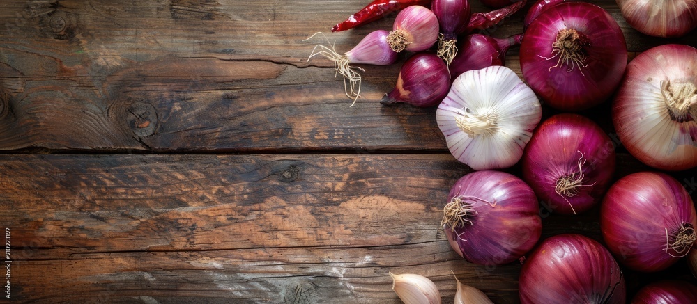 Poster Red onions and garlic displayed on a wooden surface with copy space image