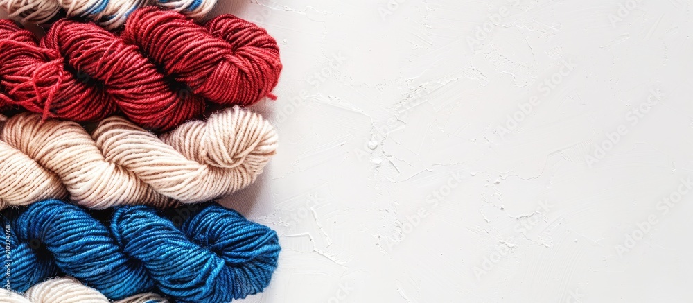 Poster Horizontal photo of red white and blue wool yarn on a white backdrop with space on the left for text or other elements. Creative banner. Copyspace image