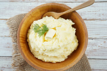 Bowl of tasty mashed potatoes with fresh dill served on wooden table