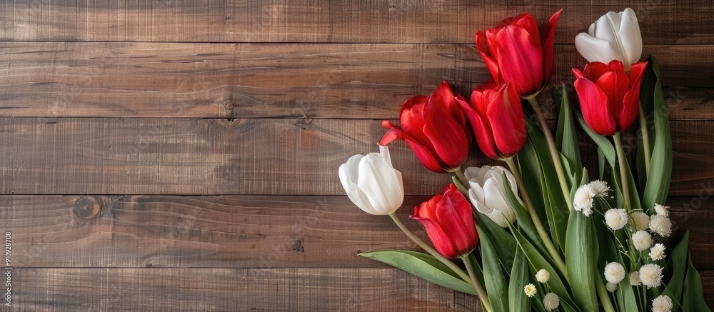 Aufkleber Top view of a vibrant red tulip bouquet contrasting against a wooden backdrop with red and white blooms perfect for adding text in the copy space image
