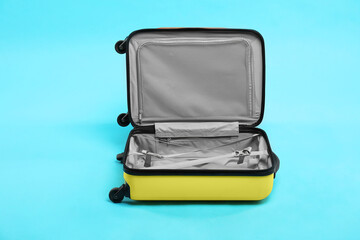 Open empty suitcase on light blue background