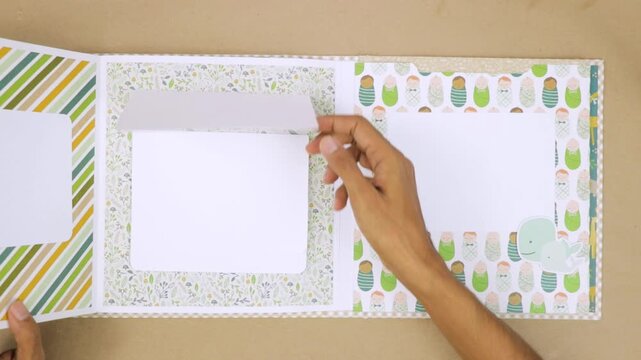 Flipping pages of baby themed scrapbook album, layout different sections for photo placement with fun designs.