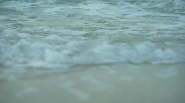 Low angle shot of surf coming towards beach.