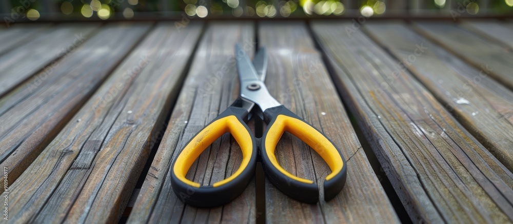 Aufkleber a set of pliers with contrasting black and yellow handles resting on a wooden floor deck in a copy s