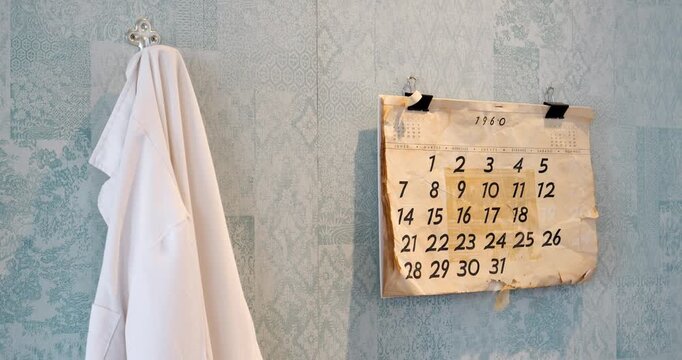A vintage scene in a laboratory featuring a wall with a white working robe hanging and a calendar on the wall dated 1960. The setting exudes an old-fashioned scientific atmosphere