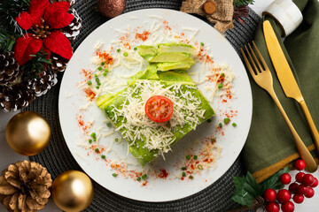 Baked potatoes with spinach bechamel and cheese on a table with christmas decorations.