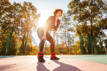 Bottom view of tired adult woman in sportswear relax after training on playground. Concept of healthy lifestyle and sport
