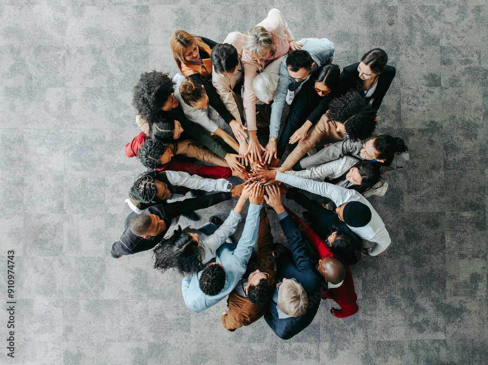 Wall mural Professional colleagues in a collaborative huddle with hands united in solidarity