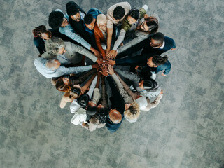 Group of diverse business colleagues showing teamwork in an office setting from above