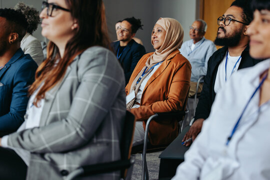 Businesswoman in hijab attending conference presentation with colleagues