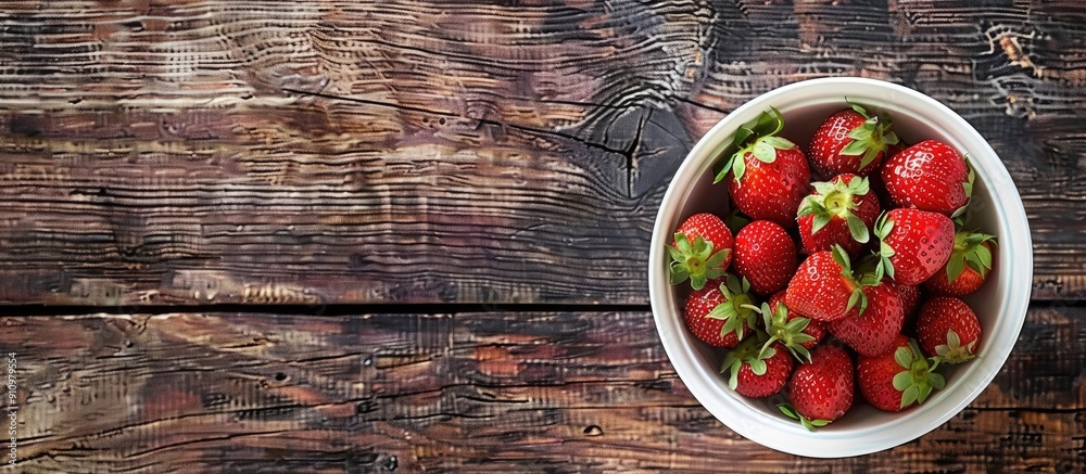 Leinwandbilder a top view copy space image features fresh strawberries in a white bowl on a rustic wooden table