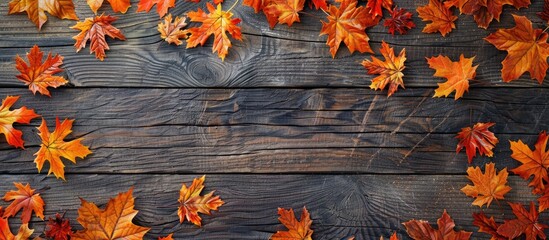 Obraz premium Fall foliage on a wooden backdrop with ample copy space image