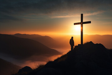 Silhouette of a Christian cross and man on a mountain top with sunset