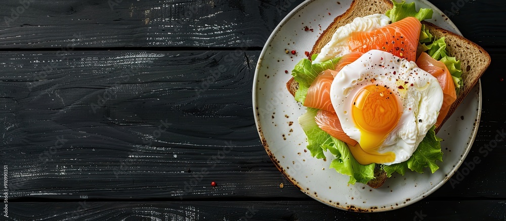 Poster Copy space image featuring a poached egg and salmon on lettuce atop toast bread for breakfast set against a sleek black wooden backdrop