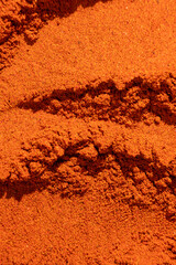 Ground paprika, red terracotta spice background, art in cooking.