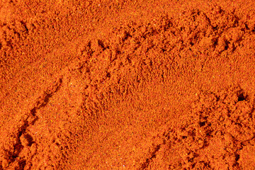 Ground paprika, red terracotta spice background, art in cooking.