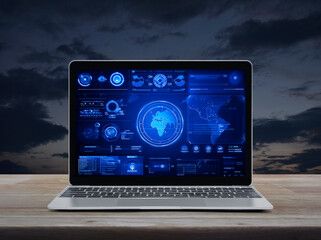 Laptop computer with digital world map with data charts and stats screen on wooden table over sunset sky, Futuristic user interface technology online concept