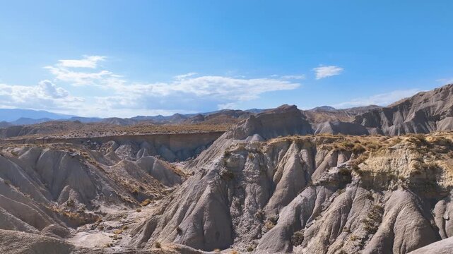 Flight into the extraordinary lunar landscape of the Tabernas desert in Almeria province Spain. Incredibly eroded and furrowed land forms topped with parched soils supporting dry tussocks and grasses.