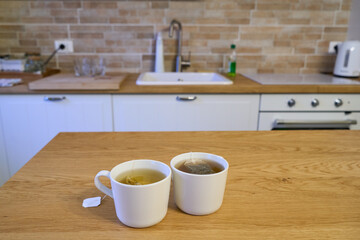 Two cups of tea on a table in a modern luxury kitchen