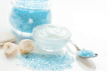 blue set for bath with salt and shells on white table background