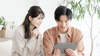 不動産サイトや旅行サイトを見るカップル