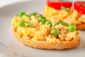 Scrambled eggs on toast, side view. Homemade breakfast - sandwiches with fried eggs.