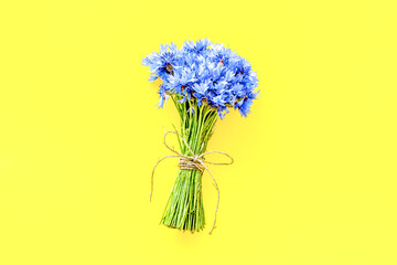 Summer design for blog with bouquet of blue cornflowers on yello