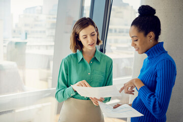 Young multiracial business colleagues reviewing documents at office