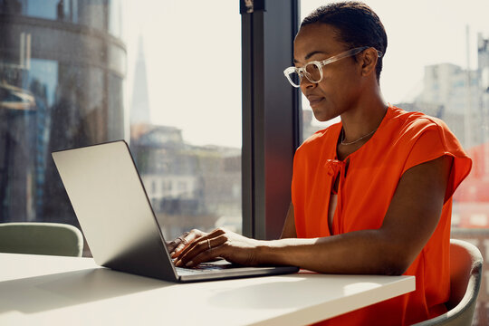 Focused businesswoman working on laptop at desk in office