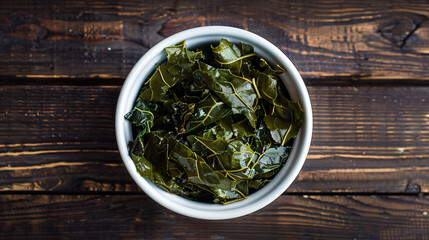 Green tea leaves spilling out of a white bowl on a rustic wooden table