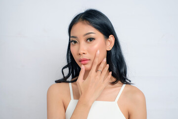 Radiant Asian Woman with Large Eyes in White Dress Toucing Face Skin Problems