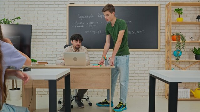 Student and Instructor Discuss Python Code in Modern Classroom
