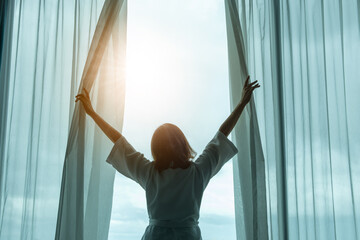 The woman was at the window in the bedroom. She opened the curtains on the window. In the morning...