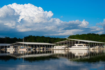 Boats docked at a marina with bright blue sky reflected in the water at Harrison Bay State Park, Tennessee