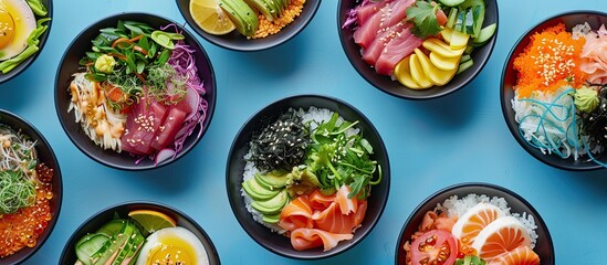 Various poke bowl arrangements displayed from above on a blue background for copy space image