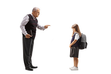 Full length profile shot of a teacher reprimanding a sad pupil