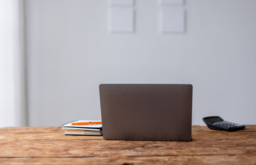 Naklejka premium Laptop Computer, notebook, and eyeglasses sitting on a desk in a large open plan office space after working hours 