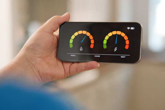 Person Checking Energy Consumption and Water Usage Levels on Smartphone Display