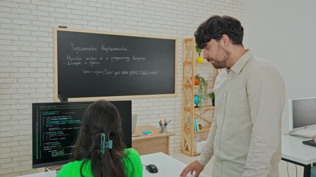 Instructor Providing One-on-One Coding Assistance in Classroom