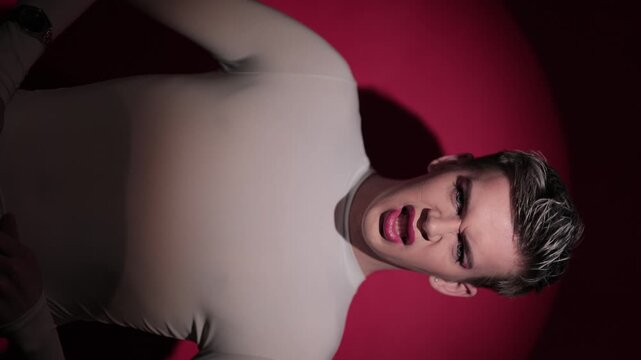 Young man with pink makeup, guys sings a song