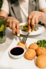 delicious dish with a breaded cutlet, fresh vegetables, and cranberry sauce on a beautiful white plate in a cozy nice restaurant