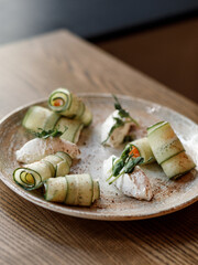 delicious dish with thinly sliced juicy cucumber, fresh tomatoes, and creamy cheese on a beautiful white tablecloth in a cozy nice restaurant