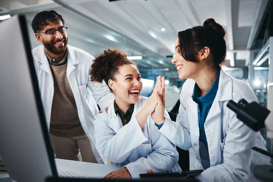 Computer, scientist and women with success, medical research and celebration for results of test and man. Lab, online and conversation for medicine of healthcare, pharmaceutical and high five