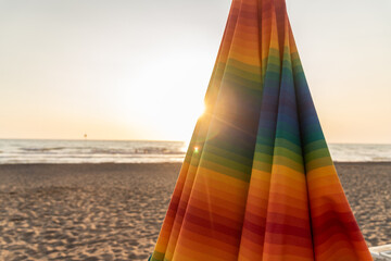 Zusammengefaltete, bunte Sonnenschirme am Abend am Strand in Nahaufnahme
