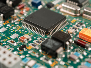 Close-up of ICs, chips, diodes and capacitors on a printed circuit board showing electronic...