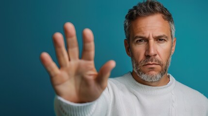 Naklejka premium Portrait of white man doing stop sing with palm of hand. Warning expression with negative and serious gesture on face