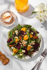 Delicious salad with baked beetroots and oranges on plate