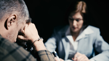 Arrested man refusing to testify or sign a confession, interrogation scene
