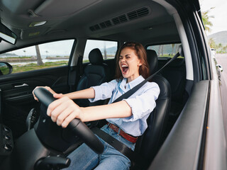 Woman driving, screaming at the top of her lungs with hands on the steering wheel, eyes wide open, in a state of extreme distress or anger, reflecting a moment of intense emotion or road rage
