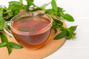 Cup of mint tea on table background. Green tea with fresh mint top view with copy space